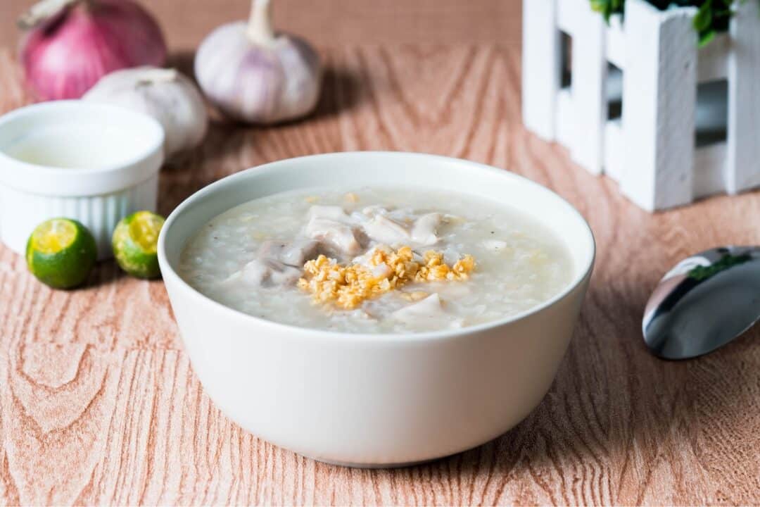 a bowl of chinese congee on a wooden table