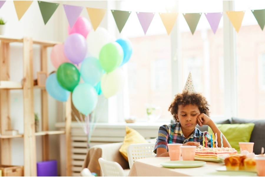 child sad at birthday party
