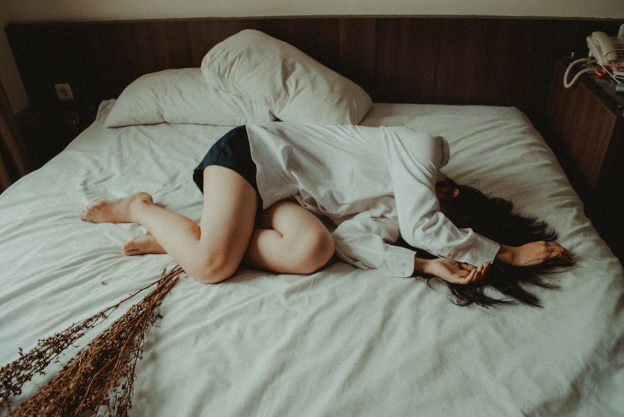 sad person lying in bed