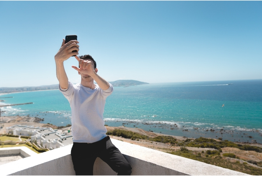 man taking selfie with ocean view