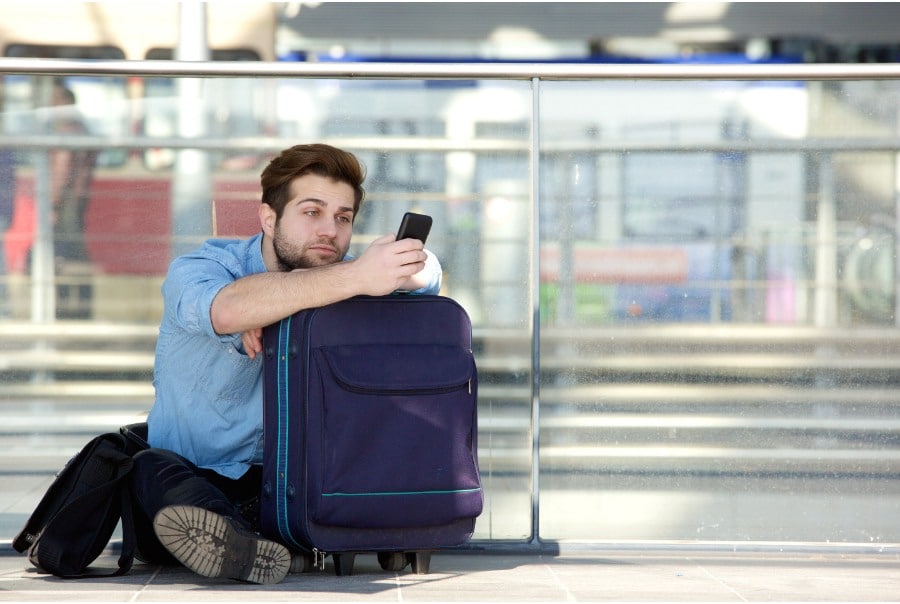 man looking at his phone while waiting at the airport