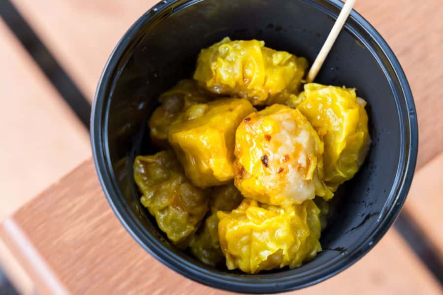 a bowl of steamed pork dumplings with soy sauce