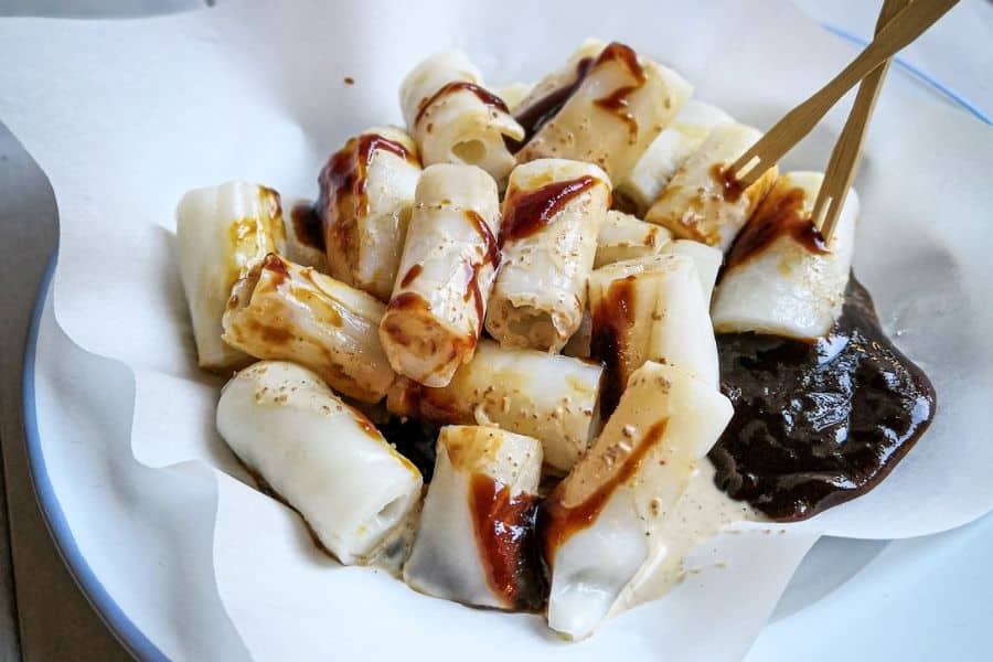 a bowl of rice noodle rolls with sweet sauce